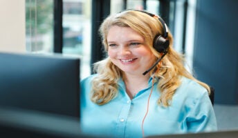 Smiling woman with headset. Source: Tech.co