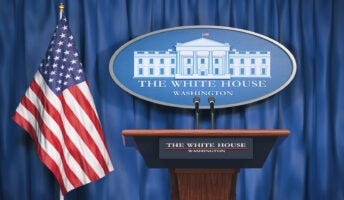 White House lectern in front of US flag