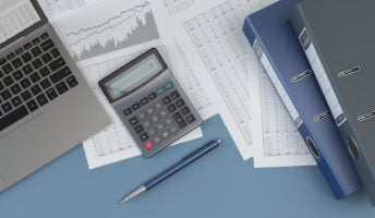 Laptop, pen, papers, calculator, and folders on a desk