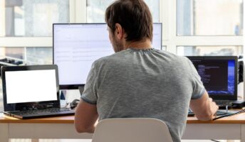 Man using three laptops