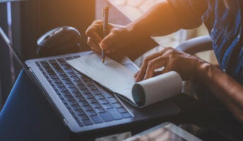 Man works at laptop computer writing pay check illustrating concept of payroll software