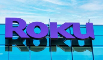 Roku sign on company office building under partly cloudy sky