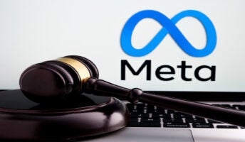 meta logo on screen with gavel on keyboard