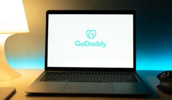 GoDaddy website builder logo on a laptop