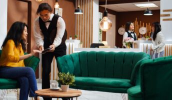 A person takes a payment in a hotel lobby.