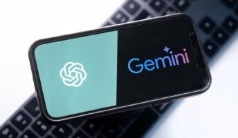 ChatGPT vs Google Gemini logos on smartphone screen against keyboard background