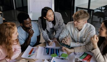 Marketing managers creating SMART objectives around a table.