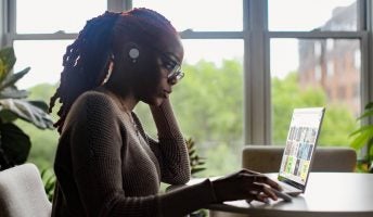 A woman with a laptop on a table in her home office