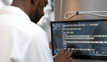 A restaurant worker uses SpotOn POS on a mounted display