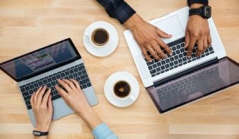 Two people using laptops