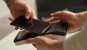 A worker takes payment with a mobile POS device.