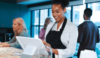 A woman in a cafe uses a POS machine. Source: Tech.co