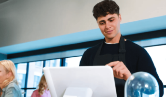 A cafe worker uses a POS system. Source: Tech.co